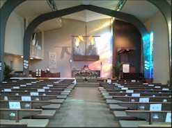 Interior of a church with wooden pews and an altar at the front.