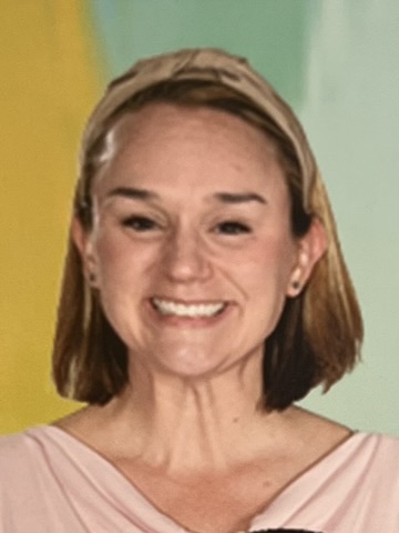 Smiling woman with short hair and a light pink top.